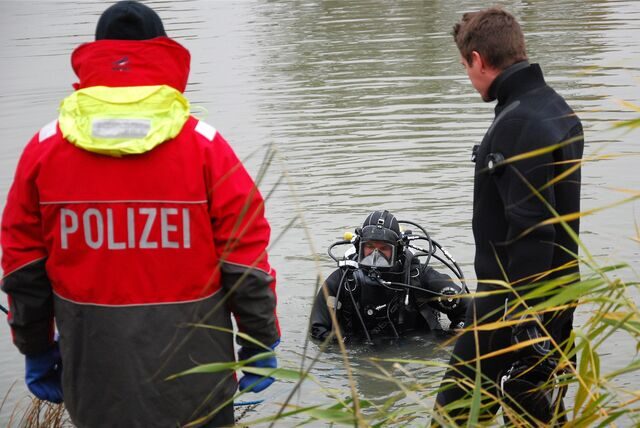 Am Datteln-Hamm-Kanal in Waltrop ist ein Taucher im Wasser, zudem sind zwei Polizisten zu sehen.
