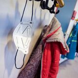 Eine FFP2-Maske hängt an Garderobenhaken vor einem Unterrichtsraum