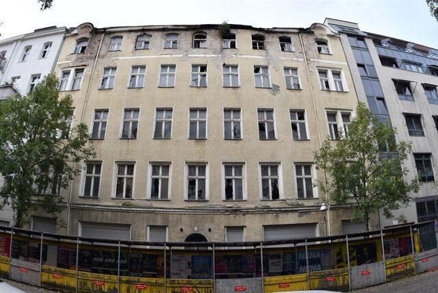 Kaputte Fenster und bröckelnder Putz an einem Wohnhaus