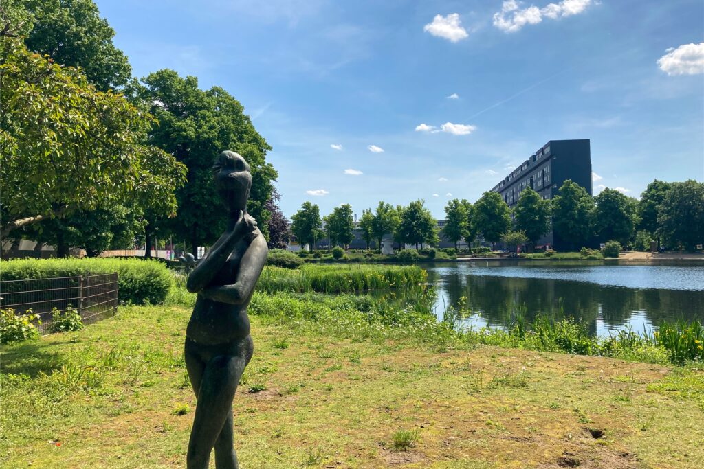Eine Frauenskulptur steht vor dem Citysee.