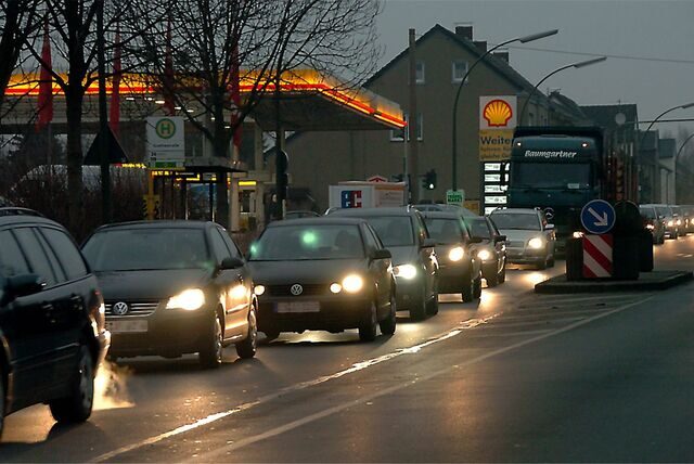Eine Schlange von Autos fährt in der Dunkelheit über die Leveringhäuser Straße, im Hintergrund die Shell-Tankstelle.