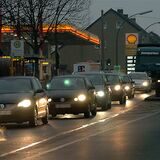 Eine Schlange von Autos fährt in der Dunkelheit über die Leveringhäuser Straße, im Hintergrund die Shell-Tankstelle.