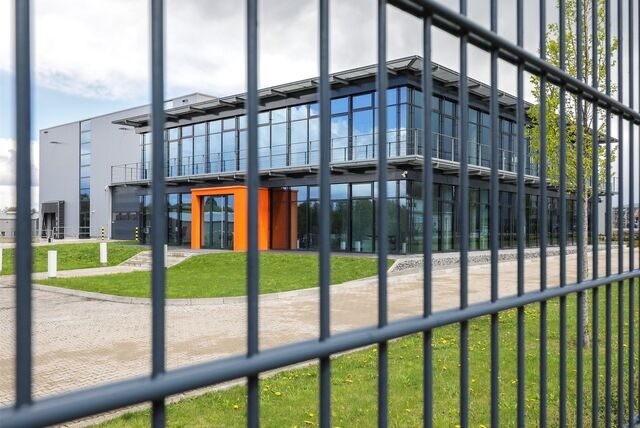 Das Firmengebäude des Unternehmens Kemper Storatec in Waltrop, durch einen Zaun hindurch fotografiert.