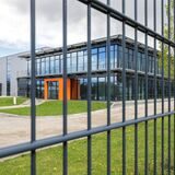 Das Firmengebäude des Unternehmens Kemper Storatec in Waltrop, durch einen Zaun hindurch fotografiert.