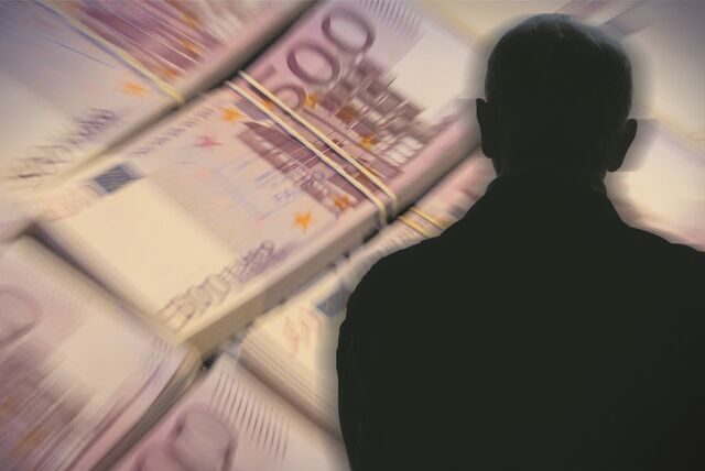 Vor einem Bündel 500-Euro-Geldscheine ist ein Schattenriss einer Person zu sehen (Symbolbild).
