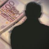 Vor einem Bündel 500-Euro-Geldscheine ist ein Schattenriss einer Person zu sehen (Symbolbild).