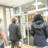 Vier Personen warten vor dem Bürgerbüro in Waltrop.