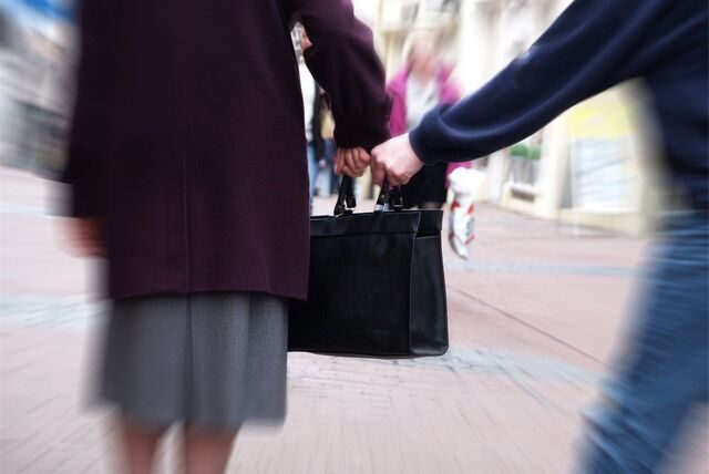 Ein Mann versucht einer Frau die Handtasche zu entreißen. (Symbolbild)