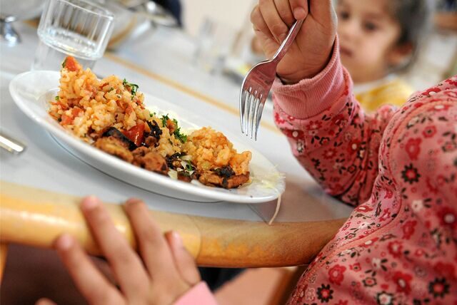 Schüler sitzen beim Mittagessen in der Mensa einer Grundschule.