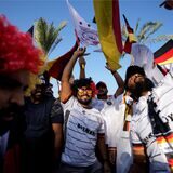 Fußball-Fans in Deutschland-Trikots schwenken Deutschland-Fahnen unter Palmen in Katar