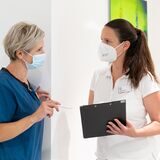 Dr. Sonja Liebeskind steht im MVZ-Flur und spricht mit einer Kollegin.