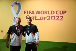 Hansi Flick und Joshua Kimmich posieren vor einer Wand.