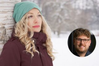 frau schaut im winterlichen wald betrübt in die leere