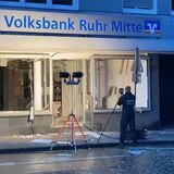 Ein Polizist macht Aufnahmen von der zerstörten Volksbank-Filiale in Herten.