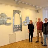Abi Shek, Kathrin Pieren und Thomas Redder stehen vor einem Kunstwerk, das einen Toraschrein und zwei Löwen zeigt.