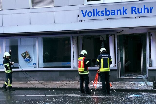 Feuerwehrleute bauen Lichtstrahler auf, um die Ermittlungsarbeit der Polizei zu unterstützen.