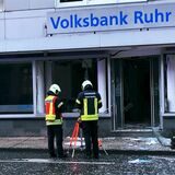 Feuerwehrleute bauen Lichtstrahler auf, um die Ermittlungsarbeit der Polizei zu unterstützen.