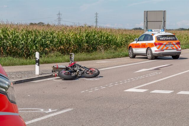 Ein Motorrad liegt an einer Unfallstelle auf der Landesstraße.