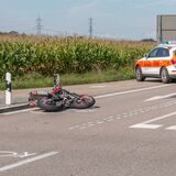 Ein Motorrad liegt an einer Unfallstelle auf der Landesstraße.
