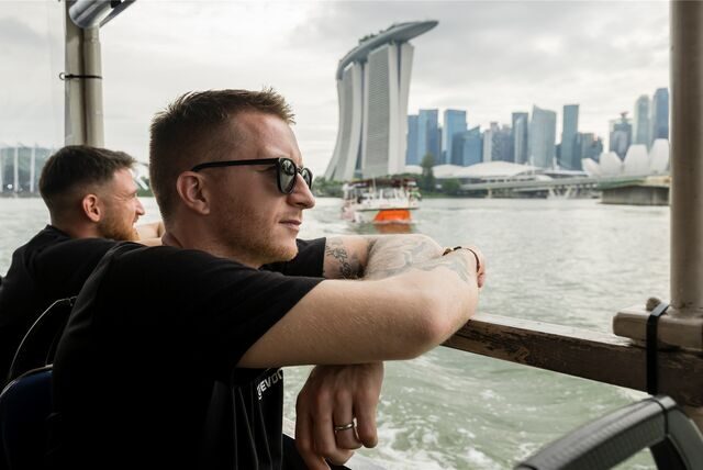 Marco Reus blickt von einem Boot aus auf die Skyline Singapurs.