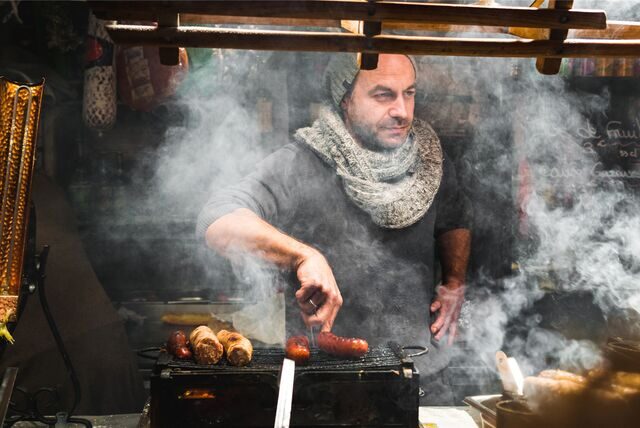 Mann an einem Bratwurststand.