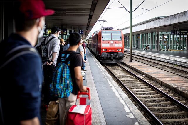 Menschen warten auf eine Regionalbahn.