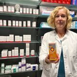 Mitarbeiterin Mirna Gawriloff steht mit einem Fiebersaft für Kinder vor einem Medikamentenregal in der Distel-Apotheke in Herten.
