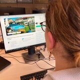 Eine Frau schaut auf eine Immobilienanzeige auf einem Computerbildschirm.