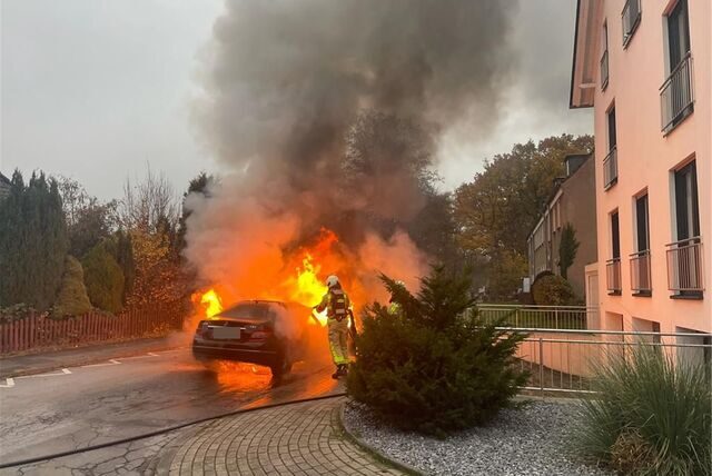 Einsatzkräfte der Feuerwehr Waltrop löschen ein brennendes Auto.