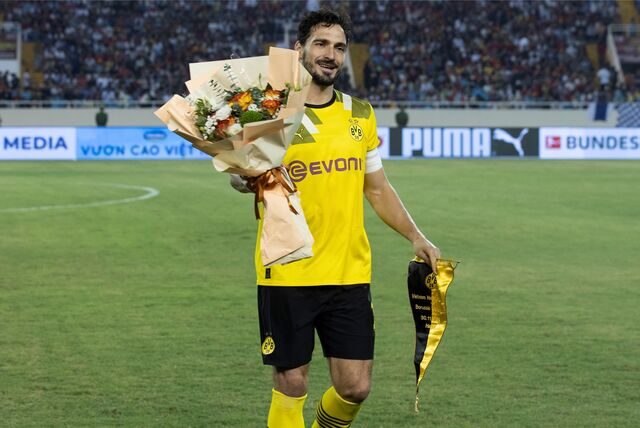 Mats Hummels geht mit einem Blumenstrauß vom Platz.
