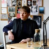 Der aus Recklinghausen stammende Künstler Hendrik Otremba sitzt an einem Schreibtisch, hinter ihm hängen an einer Pinnwand verschiedene Zettel.
