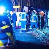 Ein verunglückter Leichenwagen steht am Straßenrand, davor Einsatzkräfte der Polizei