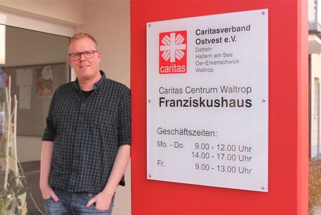 Schuldnerberater Sebastian Hermes vor einem Schild des Franziskushauses in Waltrop; dort hat er sein Büro.