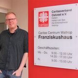 Schuldnerberater Sebastian Hermes vor einem Schild des Franziskushauses in Waltrop; dort hat er sein Büro.