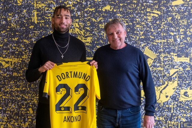 Akono hält sein Trikot hoch.