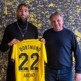 Akono hält sein Trikot hoch.