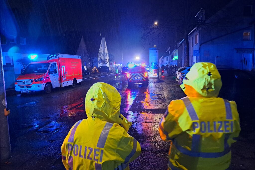 Zwei Polizisten sperren den Bachackerweg auf Höhe der Sparkassenfiliale ab.