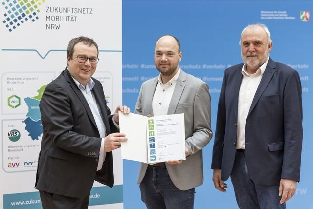 Oliver Frischer, Minister für Umwelt, Naturschutz und Verkehr, überreicht Gerrit Schweigart (Stadt Dorsten, Mitte) als Absolventen des Lehrgangs Kommunale Mobilitätsmanager die Abschlussurkunde.