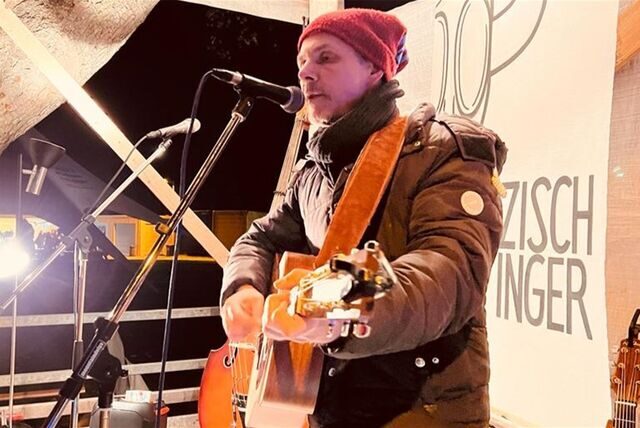 Der Waltroper Musiker steht mit seiner Gitarre auf einer Bühne.