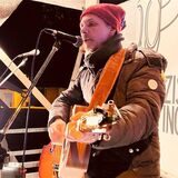 Der Waltroper Musiker steht mit seiner Gitarre auf einer Bühne.