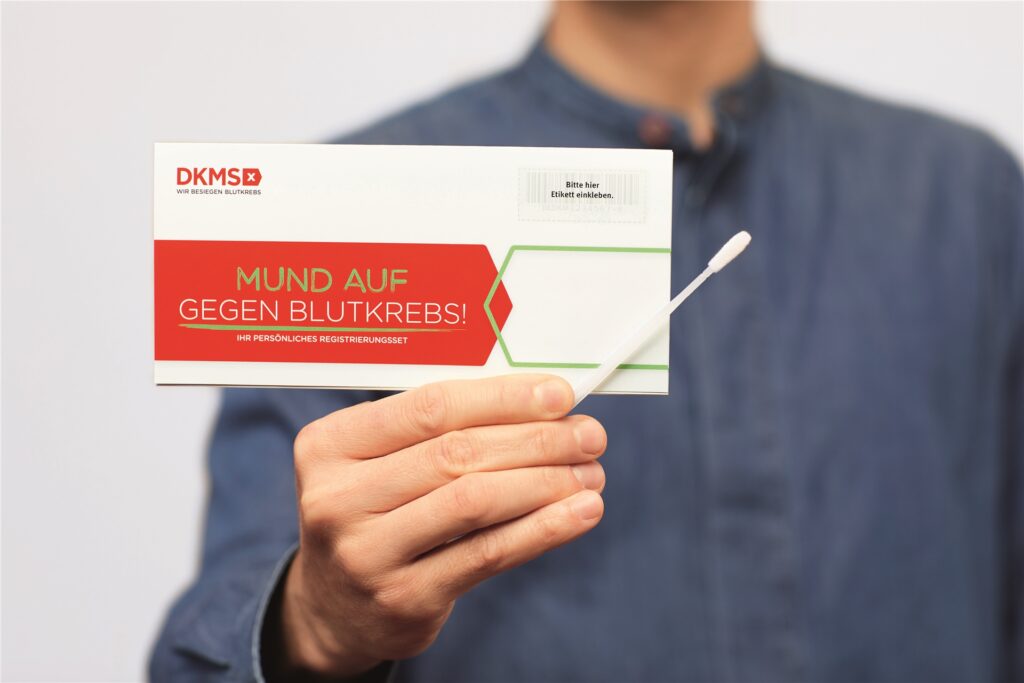 Eine Person hält ein Registrierungs-Set der DKMS in der Hand.