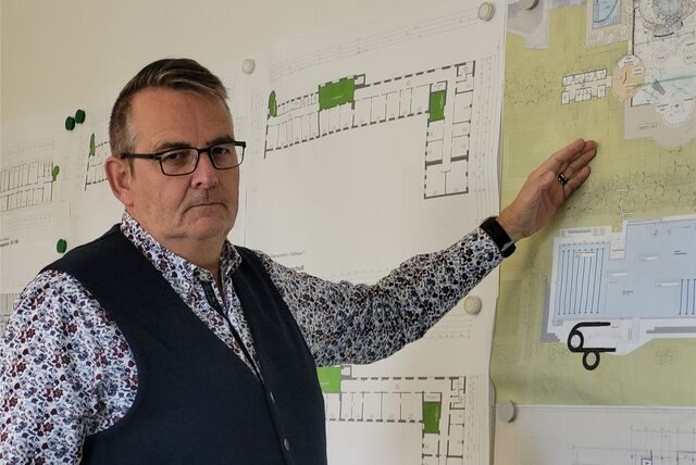 Stadtkämmerer Heinz Schnettger steht vor einer Plankarte des zu sanierenden Maritimo-Freizeitbades in Oer-Erkenschwick.