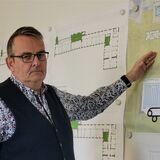 Stadtkämmerer Heinz Schnettger steht vor einer Plankarte des zu sanierenden Maritimo-Freizeitbades in Oer-Erkenschwick.