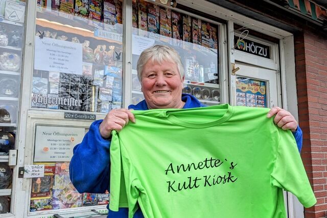 Annette Winkler hält ein grünes T-Shirt mit der Aufschrift Annette’s Kiosk in den Händen.