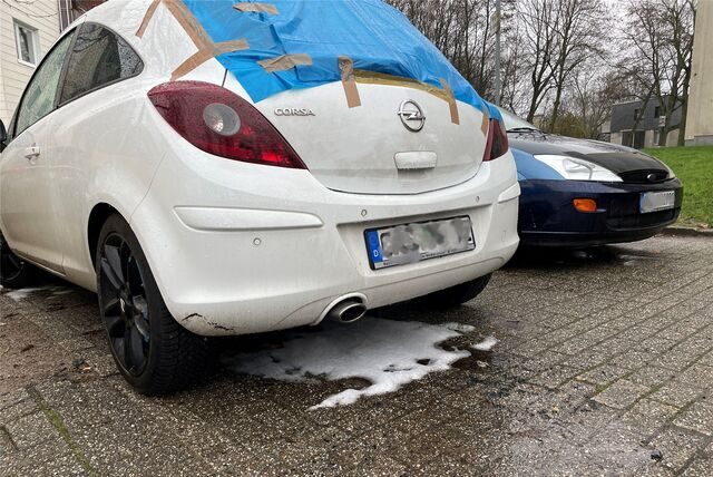 Ein Opel Corsa mit eingeschlagener Heckscheibe, die notdürftig abgeklebt ist, steht in Deininghausen (Castrop-Rauxel) auf dem Parkplatz.