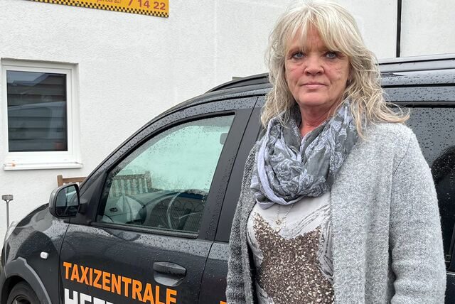 Anke Hinz steht vor einem Taxi des Dorstener Unternehmens „Taxi Heethey“.