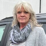Anke Hinz steht vor einem Taxi des Dorstener Unternehmens „Taxi Heethey“.