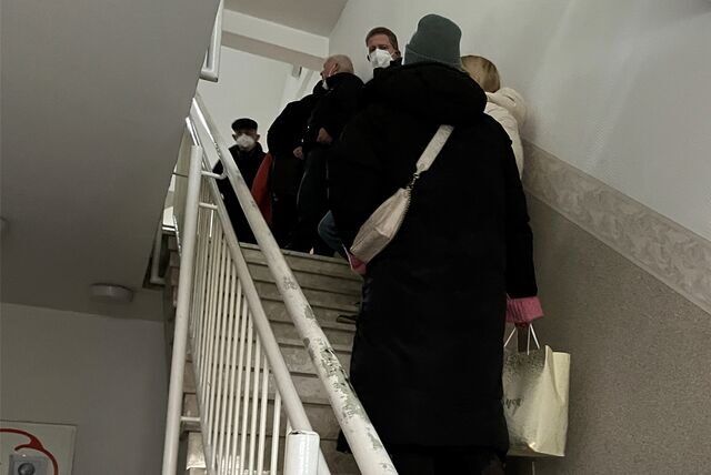Patientinnen und Patienten von Ewa Zielinski stehen im Hausflur der Praxis und möchten ihre Unterlagen haben.