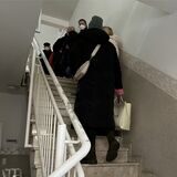 Patientinnen und Patienten von Ewa Zielinski stehen im Hausflur der Praxis und möchten ihre Unterlagen haben.