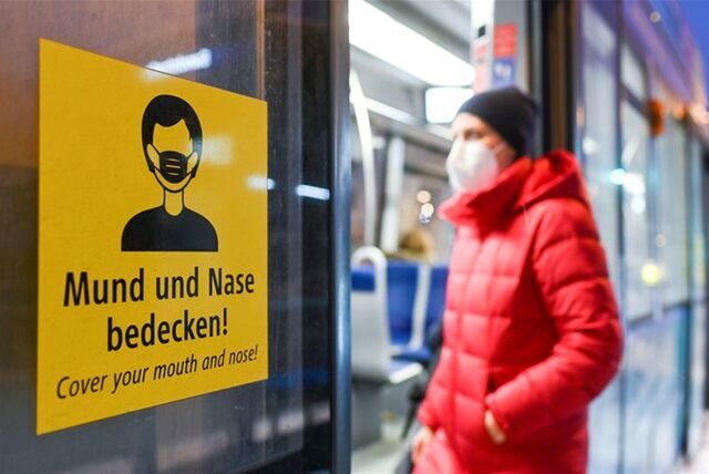 Eine Frau betritt mit FFP2-Maske eine Straßenbahn.